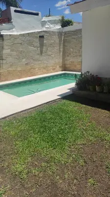 a swimming pool in front of a house at Departamento de lujo, todo confort, en el corazón de zona norte in Cordoba