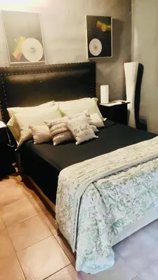 a bedroom with a large black bed with pillows at Departamento de lujo, todo confort, en el corazón de zona norte in Cordoba