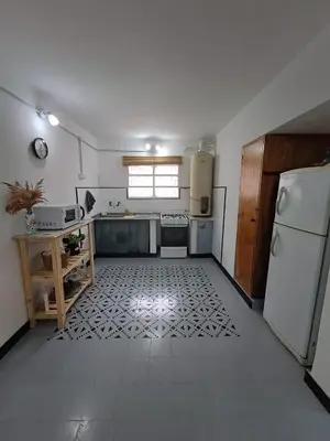 a large kitchen with a refrigerator and a window at Achalay in Bialet Massé