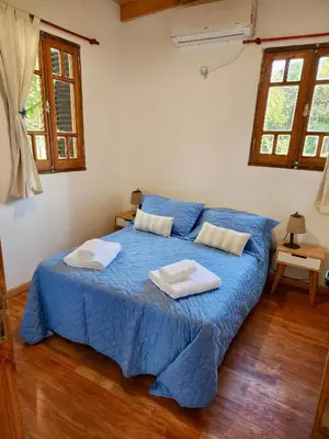 a bedroom with a blue bed with two towels on it at Cabañas Rincon del Champa in San Javier