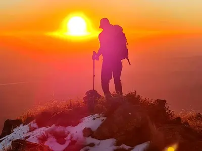 a person standing on top of a mountain at sunset at Cabañas Rincon del Champa in San Javier