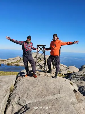 two men standing on a rock with their arms out at Cabañas Rincon del Champa in San Javier