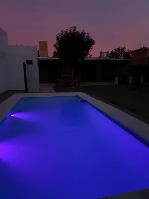 a swimming pool with blue lights in a backyard at Quincho El Aguaribay in Villa Dolores