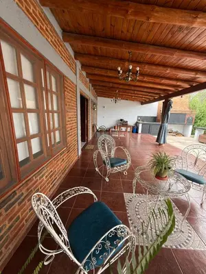 a patio with chairs and tables on a porch at Quincho El Aguaribay in Villa Dolores
