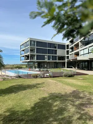 a large building with a pool in front of it at Departamento 103 - Puerto del Aguila Country Nautico in Potrero de Garay