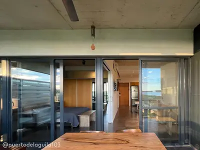 a room with glass walls and a wooden table at Departamento 103 - Puerto del Aguila Country Nautico in Potrero de Garay
