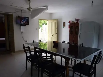 a dining room with a table and chairs and a refrigerator at MariaAurelia in Mina Clavero