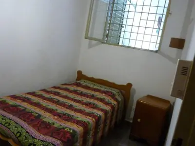a small bedroom with a bed with a quilt on it at MariaAurelia in Mina Clavero