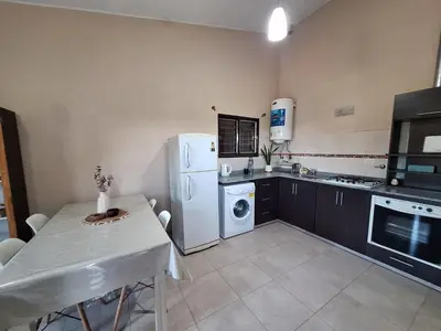 a kitchen with a table and a white refrigerator at Estancia del Alma in Villa Carlos Paz