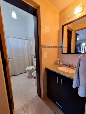 a bathroom with a sink and a toilet and a mirror at Estancia del Alma in Villa Carlos Paz