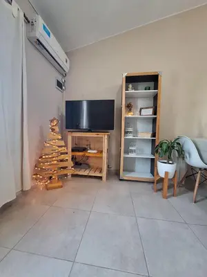 a living room with a television and a christmas tree at Estancia del Alma in Villa Carlos Paz
