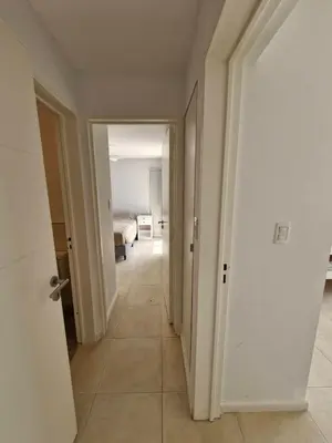 a corridor of a room with a bed and a hallway at DEPTO con piscina Climatizada para 6 in Malagueño