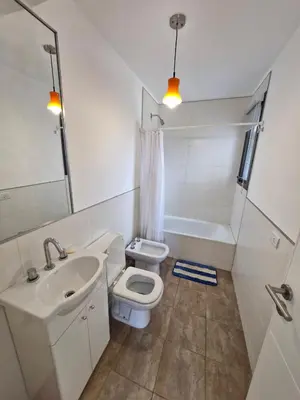 a white bathroom with a sink and a toilet at DEPTO con piscina Climatizada para 6 in Malagueño