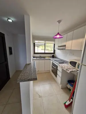 a kitchen with a counter and a purple light at DEPTO con piscina Climatizada para 6 in Malagueño