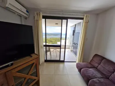 a living room with a couch and a flat screen tv at DEPTO con piscina Climatizada para 6 in Malagueño