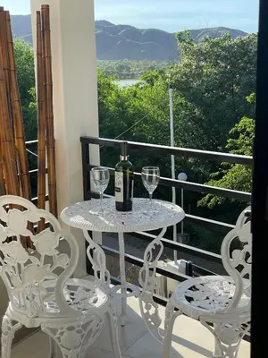a table with a bottle of wine and two chairs on a balcony at Sierra y Lago in Villa Parque Siquiman