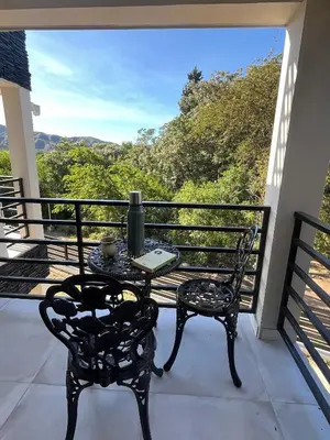 a table and chairs on a balcony with a view at Sierra y Lago in Villa Parque Siquiman