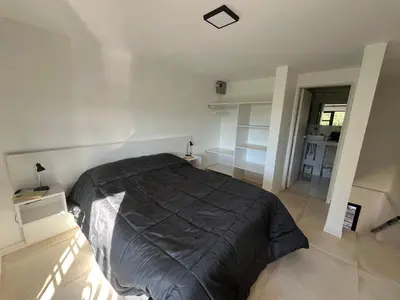 a bedroom with a bed with a black comforter at Sierra y Lago in Villa Parque Siquiman