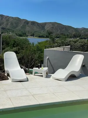 two white chairs and a table next to a pool at Sierra y Lago in Villa Parque Siquiman