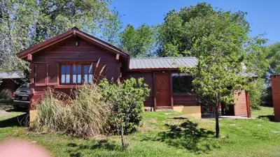 a small house in a yard with a tree at Villa Armonia in Los Reartes