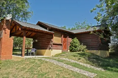 a log cabin with a porch and a patio at Villa Armonia in Los Reartes