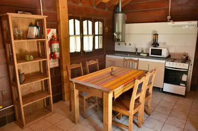 a kitchen with a wooden table and chairs at Villa Armonia in Los Reartes