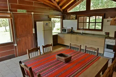 a kitchen with a wooden table and a kitchen with a refrigerator at Villa Armonia in Los Reartes