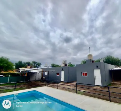 a house with a swimming pool in front of it at Departamentos Don Luis in Villa Cura Brochero