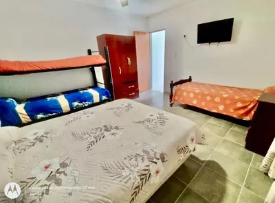 a bedroom with two beds and a flat screen tv at Departamentos Don Luis in Villa Cura Brochero