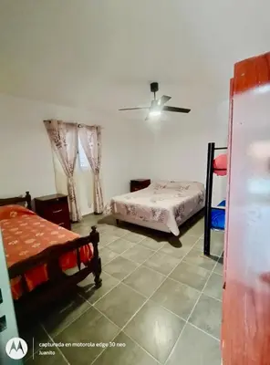 a bedroom with two beds and a ceiling fan at Departamentos Don Luis in Villa Cura Brochero