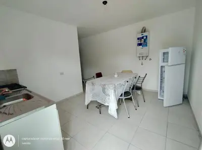 a kitchen with a table with chairs and a refrigerator at Departamentos Don Luis in Villa Cura Brochero