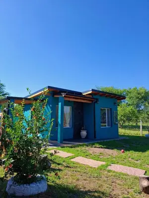 a blue house with a tree in front of it at DoñaMaria in Santa Rosa de Calamuchita