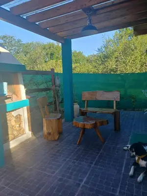 a dog sleeping on a patio with a bench and a table at DoñaMaria in Santa Rosa de Calamuchita