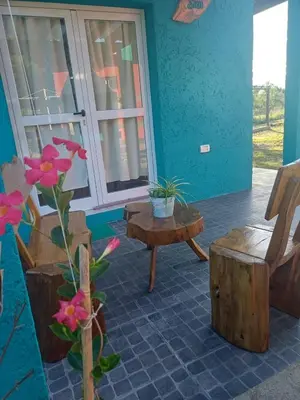 a room with a bench and a table and flowers at DoñaMaria in Santa Rosa de Calamuchita