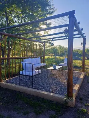 two chairs and a table under a pergola at DoñaMaria in Santa Rosa de Calamuchita