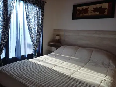 a bedroom with a bed and a window with curtains at DoñaMaria in Santa Rosa de Calamuchita