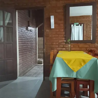 a table with a yellow and green table cloth on it at Hostería HuAneL in Villa Cura Brochero
