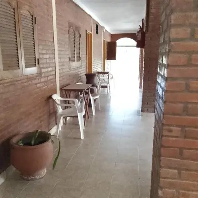 a room with tables and chairs and a brick wall at Hostería HuAneL in Villa Cura Brochero