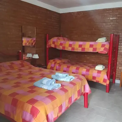 two beds in a room with towels on them at Hostería HuAneL in Villa Cura Brochero