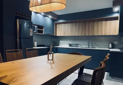 a kitchen with a wooden table and blue cabinets at Casa lujosa en Tanti in Tanti
