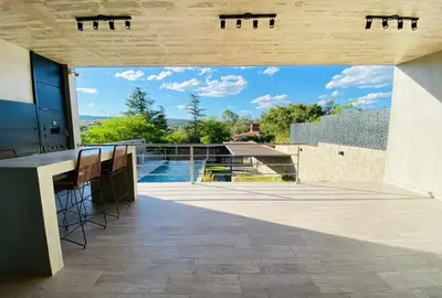 an outdoor patio with a view of a swimming pool at Casa lujosa en Tanti in Tanti