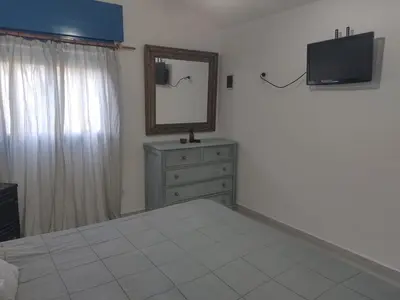a bedroom with a bed and a mirror and a dresser at La Calma in Los Reartes