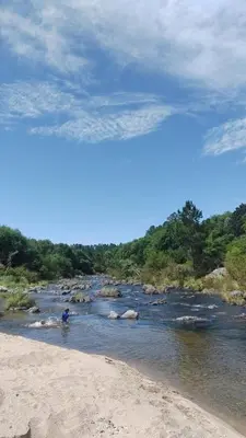 a person standing in the water near a river at La Calma in Los Reartes