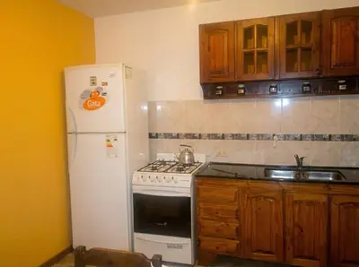 a kitchen with a white stove and a refrigerator at Brisas Serranas Departamentos in Villa Carlos Paz