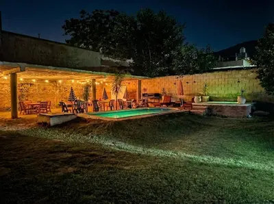 a backyard with a swimming pool at night at Brisas Serranas Departamentos in Villa Carlos Paz