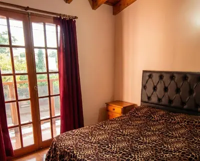 a bedroom with a bed and a large window at Brisas Serranas Departamentos in Villa Carlos Paz