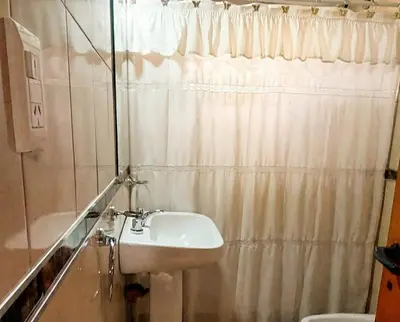 a bathroom with a sink and a shower curtain at Brisas Serranas Departamentos in Villa Carlos Paz