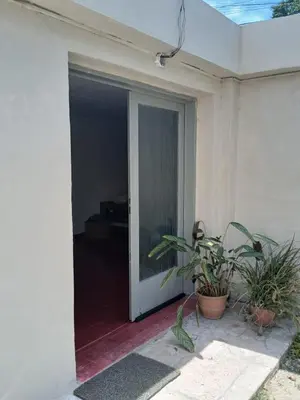 an open sliding glass door of a house with plants at Casa Henry in Cordoba