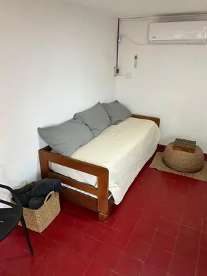 a bed in a room with a red floor at Casa Henry in Cordoba