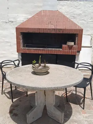 a stone table and chairs with a fire place at Casa Henry in Cordoba